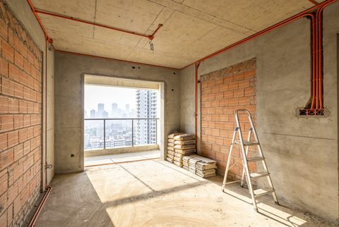 Mid-construction Indian apartment interior with electrical conduit visible in the walls